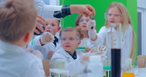 Teacher and Students Doing Science Experiment in School Classroom