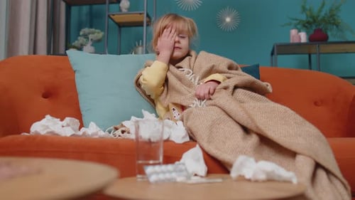 Ill Child Resting on Couch with Blanket