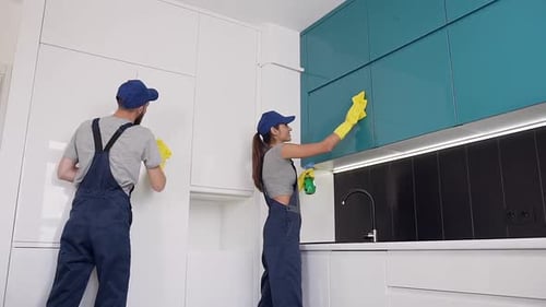 Happy Smiling People of the Cleaning Office Wipping the Kitchen Furniture