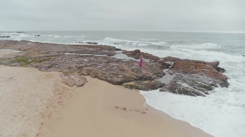 Woman In A Dress Wandering On The Beach