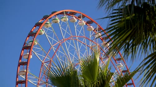Amusement Park Ferris Wheel Slowly Turning Against Blue Sky