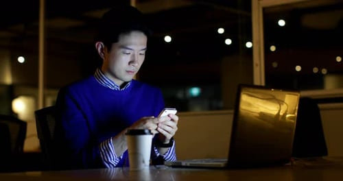 Male executive using mobile phone at desk in office 4k