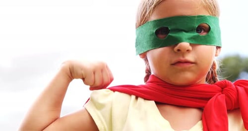 Girl Superhero Flexes Muscles Outside on Sunny Day
