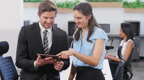 Colleagues Collaborating on Tablet in Modern Office
