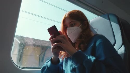Girl Sitting on Train Using Smartphone