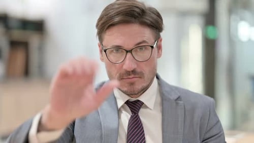 Serious Man Gestures Stop in Office Environment