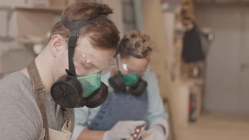 Carpenters Polishing Wooden Items in Workshop