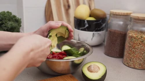 Preparing Fresh Salad with Avocado in the Kitchen