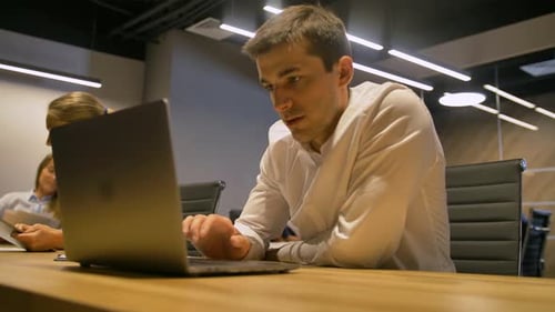 Young Businessman Working on Modern Loft Office at Night.