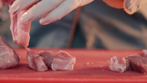 Cutting Raw Meat with a Knife Close Up