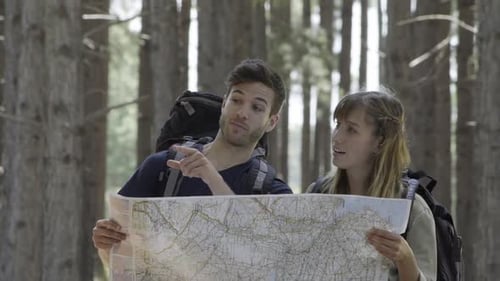 Young Couple Reading a Map in a Forest