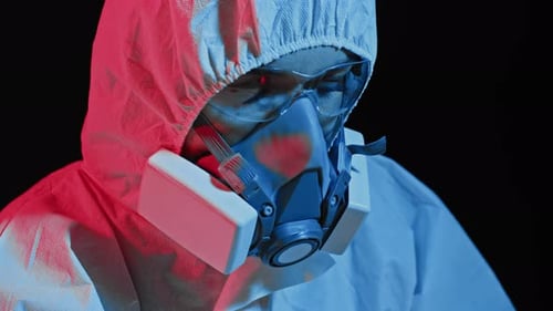 Person in Hazmat Suit and Respirator Mask