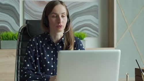 Young Woman Using Video Chat on Laptop in Office