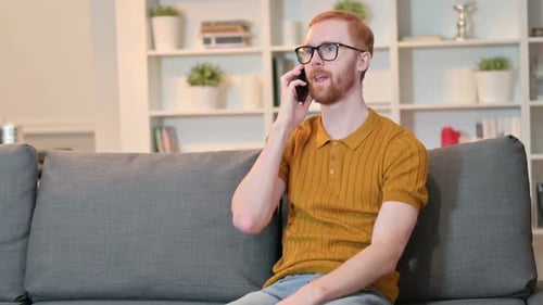 Redhead Young Adult Talking on Smartphone at Home