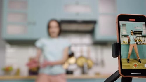 Young Woman Dancing in Kitchen, Recording with Phone