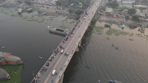 Vue aérienne de la circulation sur un pont à Old Dhaka Steamer Ghat avec des voitures et des navires traversant le long de Buri