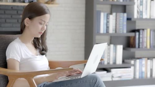 Woman Using Laptop and Smiling at Home