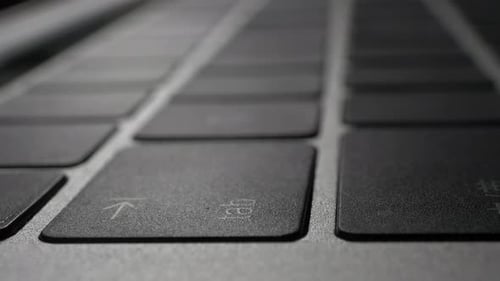 Human finger pressing on the enter return shift delete tab key on laptop keyboard