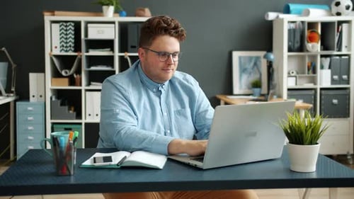 Serious Businessperson Handsome Guy Typing Using Laptop Computer Indoors in Office