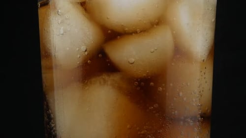cola with ice cubes close up