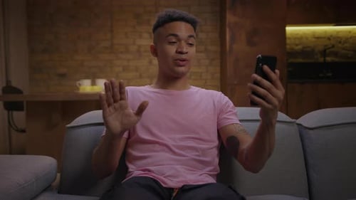 Young Adult on Video Call Laughing and Waving