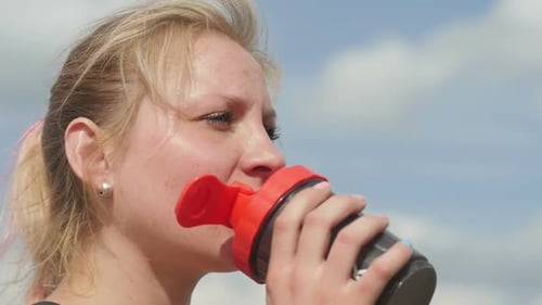 Woman Drinks Protein Shake After Workout Outdoors