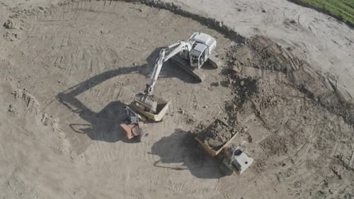 Excavator Loading Dirt Into Truck at Construction Site