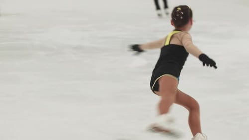 Girl Ice Skating Gracefully at Indoor Ice Rink
