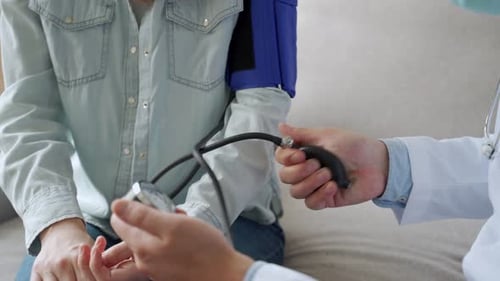 Doctor Measures Patient's Blood Pressure with Manual Cuff