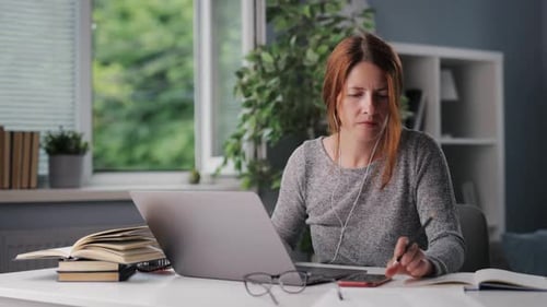 Woman Working on Laptop at Bright Home Desk