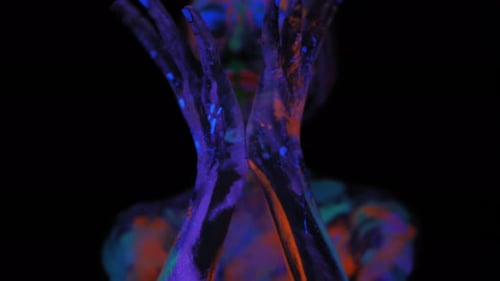 Fille avec un motif UV, elle bouge ses mains à la lumière d'une lampe fluorescente
