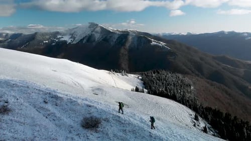 Flying Over Two Hikers Walking on Mountain Ridge