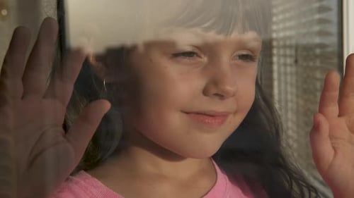 Little Girl Gazing Out Sunny Window Close Up