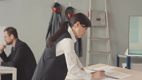 Female Asian Architect Engineer Drawing Blueprint in Office