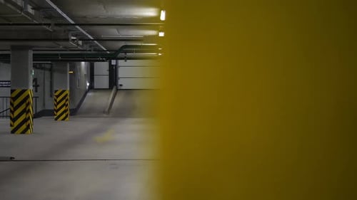 Empty Underground Parking Garage with Yellow Support Beams