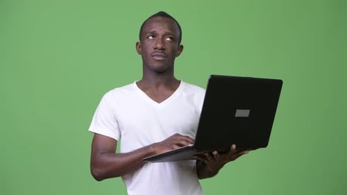 Young Adult Holding Laptop, Thinking on Green Screen