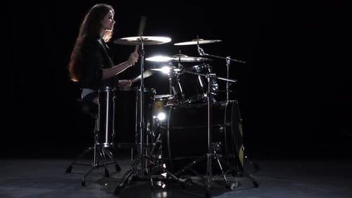 Woman Drummer Plays Backlit Drum Set in Studio