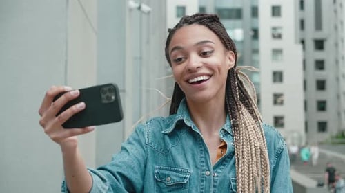 Woman With Braids Using Smartphone in City