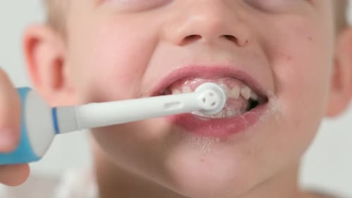 Child Brushing Teeth with Electric Toothbrush Close Up