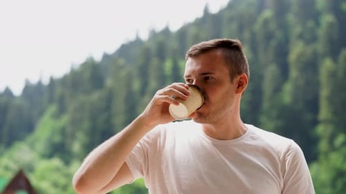 Young Adult Drinking Coffee Outside in Nature