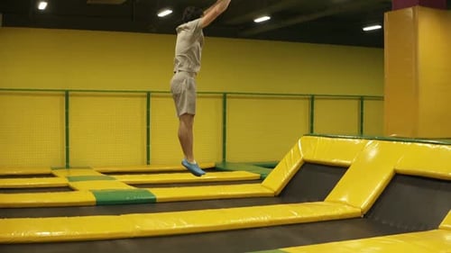 Young Man Performing Gymnastics on Trampoline