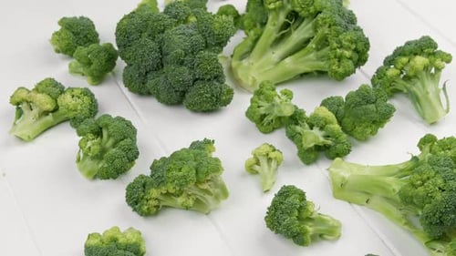Fresh Broccoli Florets Scattered on a White Table