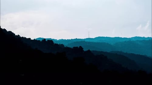 Time lapse beautiful nature of blue sky and clouds at sunrise with silhouettes of mountains.