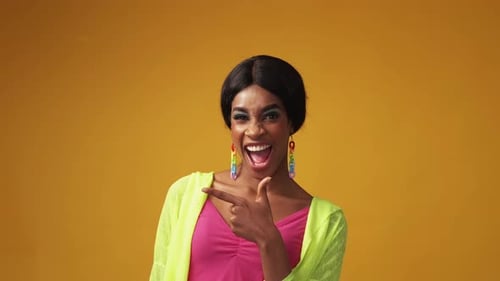 Excited Woman Gestures in Front of Yellow Background