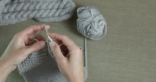 Hands Knitting Gray Wool with Knitting Needles