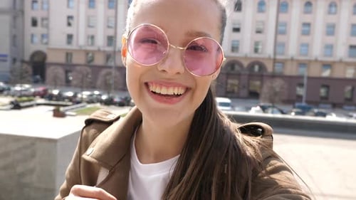 Smiling Woman in Sunglasses Posing in City