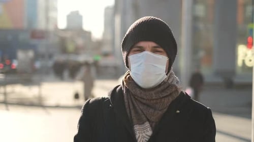 Man in Mask Standing on City Street