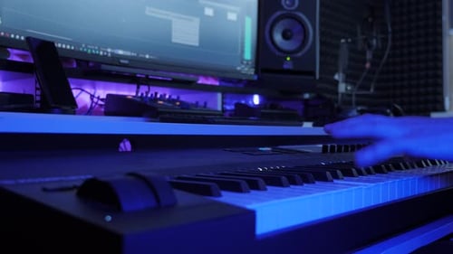 Musician playing keyboard. Man playing on synthesize at sound record studio