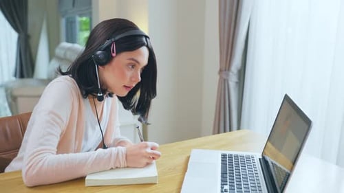 Woman Attends Online Meeting and Takes Notes