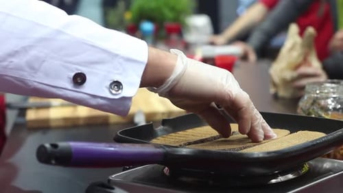 Chef Grilling Bread in a Kitchen
